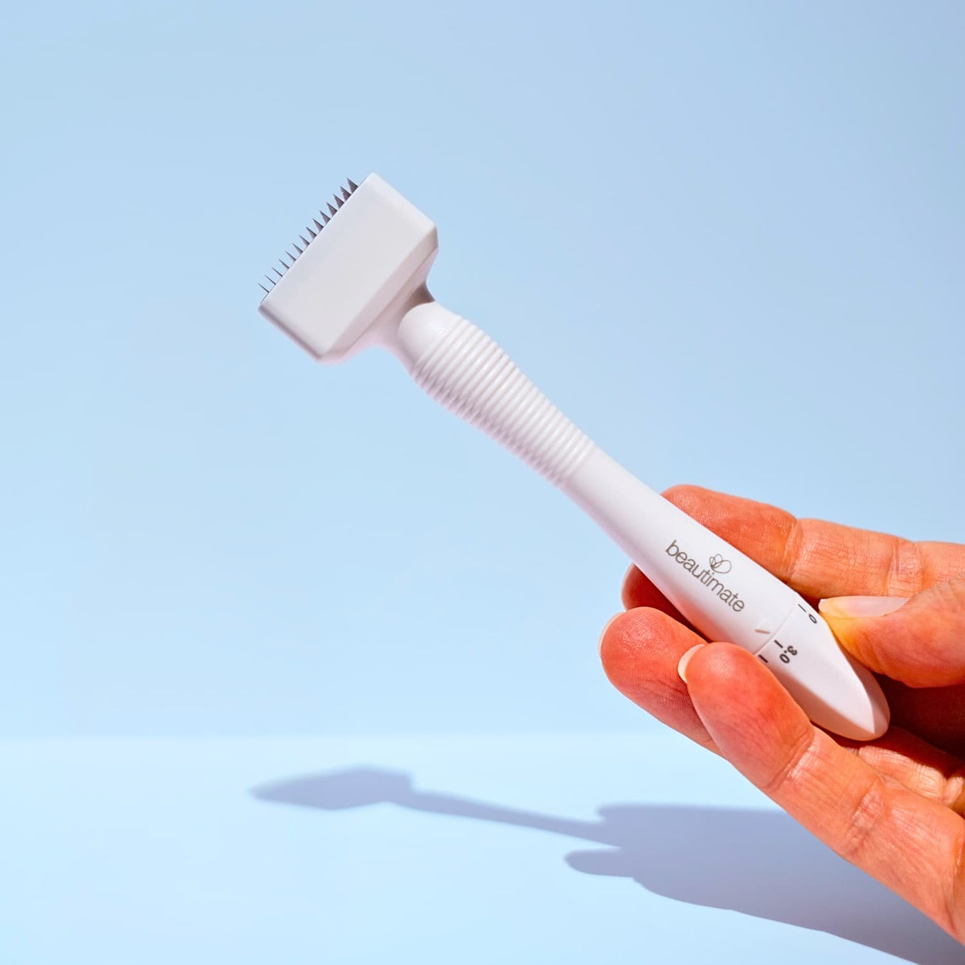 Hand holding Beautimate Adjustable Derma Stamp — at-home microneedling
tool for face and scalp